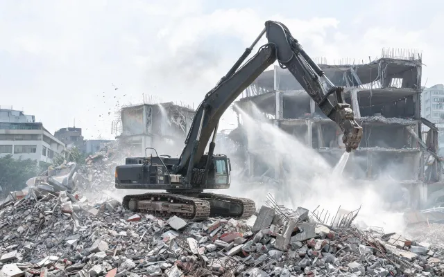 High-reach demolition excavator tracks on rubble
